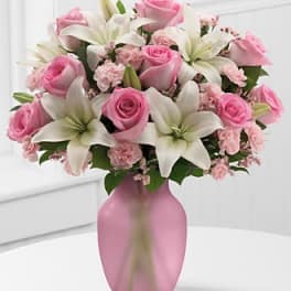 Pink roses and white lilies arranged in a pink vase