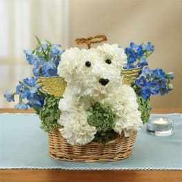 White flower teddy bear in a wicker basket with blue flowers