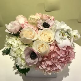 Pastel bouquet of roses, hydrangeas, and anemones in a white box