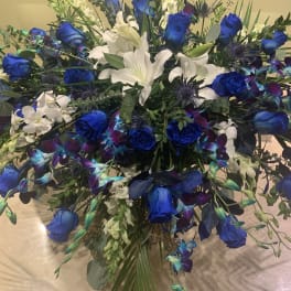 Large bouquet of blue roses and white lilies with mixed greenery