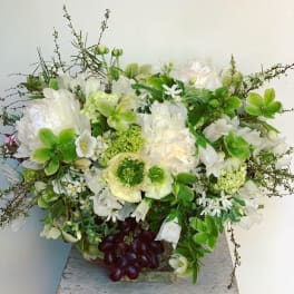 White and green floral arrangement in a low container