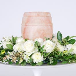 White rose and chrysanthemum arrangement around a peach urn