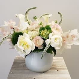 White floral arrangement in a round white vase