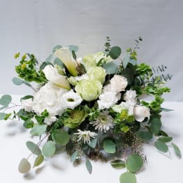 White and pale green floral arrangement with calla lilies and roses