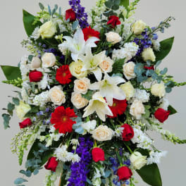 Large standing floral spray with red, white, and purple flowers on an easel