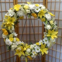 Yellow and white floral wreath on a stand