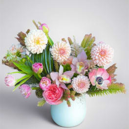 Mixed pastel bouquet in a light blue vase with pink and white blooms