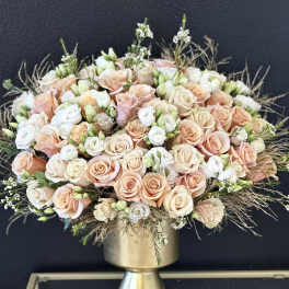 Peach and white rose bouquet in a gold pedestal vase
