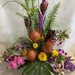 Tall tropical bouquet with purple orchids and orange pincushion blooms