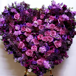 Heart-shaped floral arrangement of pink and purple roses