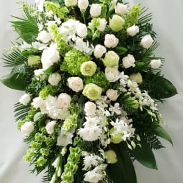 Large white and green floral standing spray on an easel