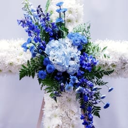 Blue and white floral cross arrangement on a stand