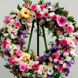 Large floral wreath with pink roses, daisies, and purple flowers