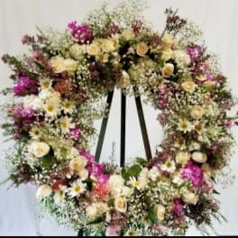Large floral wreath with cream and pink flowers on a stand