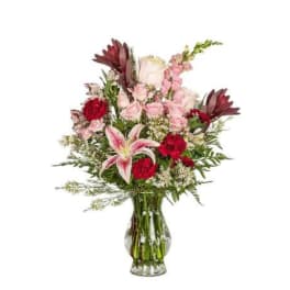 Mixed pink and red bouquet in a clear glass vase