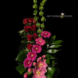 Tall floral arrangement with red roses, pink gerbera daisies, and pink lilies