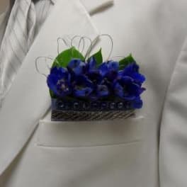 Blue boutonniere pinned to a white suit jacket
