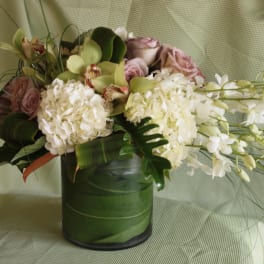 White and blush floral arrangement in a green vase