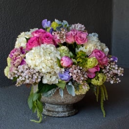 Mixed bouquet of pink roses and white hydrangeas in a stone vase