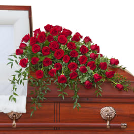 Red roses arranged on a wooden casket