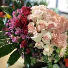 Bouquet of pink, red, and white roses with hydrangea and greenery