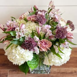Bouquet of pink and white flowers in a square glass vase