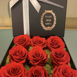 Box of red roses with a white ribbon and bow