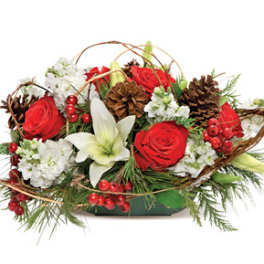 Red roses and white lilies arranged with pinecones in a low container