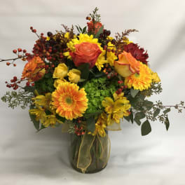 Mixed bouquet of yellow and orange flowers in a glass vase