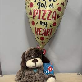 Pizza-shaped balloon above a plush dog holding a Domino's gift card