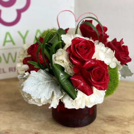 Red roses and white hydrangeas arranged in a red vase