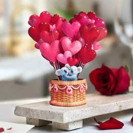 Heart-shaped balloons in a basket with a small koala figure