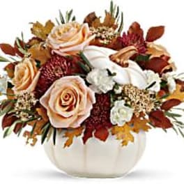 Autumn floral arrangement in a white pumpkin vase with roses and mums