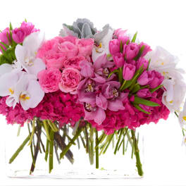 Pink and white floral arrangement in a clear rectangular vase