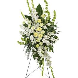 Tall white and pale yellow funeral spray on a stand