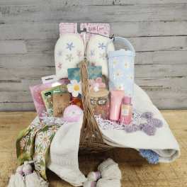 Gift basket with slippers, tumbler, bath items, and a scarf