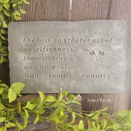 Engraved stone plaque with a patriotic quote and small flag emblem