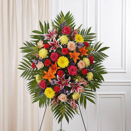 Standing floral spray with roses, lilies, and daisies on an easel