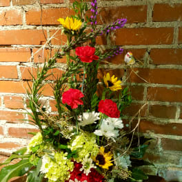 Tall mixed bouquet with sunflowers, carnations, and daisies