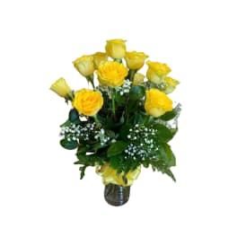 Yellow roses arranged in a glass vase with baby's breath