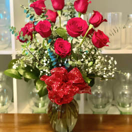 Bouquet of red roses in a glass vase with a red ribbon