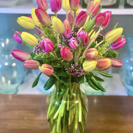 Bouquet of pink and yellow tulips in a glass vase