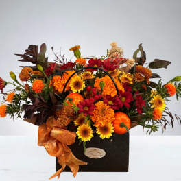 Autumn floral arrangement in a black handled box with orange ribbon