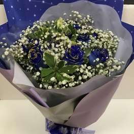 Blue roses with baby's breath in purple wrapping