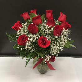 Bouquet of red roses and baby's breath in a glass vase
