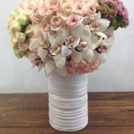 Bouquet of pale pink roses and white orchids in a white vase