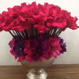 Large bouquet of hot pink roses and purple orchids in a silver vase