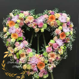 Heart-shaped floral wreath with pink, purple, peach, and green flowers