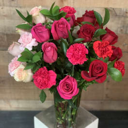 Bouquet of pink and red roses with carnations in a glass vase