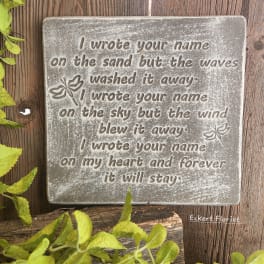 Decorative memorial plaque with a sentimental quote on a wood background